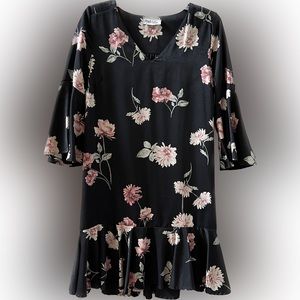 Boutique floral on black dress with ruffled hem.